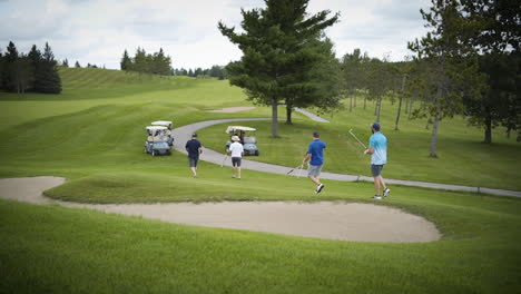 Eine-Gruppe-Von-Freunden-Geht-Auf-Dem-Fairway-Auf-Ihre-Golfwagen-Zu