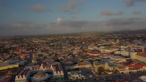 Aerial-pedestal-view-of-the-beautiful-marina-and-city-Oranjestad-of-Aruba-with-cars-driving-on-the-roads-4K