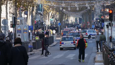 Ein-Gewerkschaftsmitarbeiter-Geht-Während-Einer-Gelbwesten-Demonstration-In-Marseille-Auf-Der-Straße-Neben-Einer-Roten-Ampel-Und-Sechs-Schräg-Abbiegenden-Polizeifahrzeugen