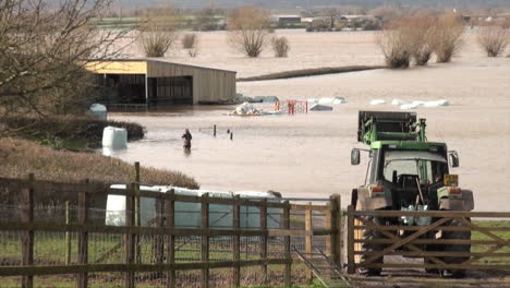 Großbritannien,-Februar-2014-–-Eine-Frau-In-Wathosen-Geht-Durch-Hüfthohes,-Tiefes-Wasser-Auf-Einer-überfluteten-Farm-Auf-Den-Somerset-Ebenen