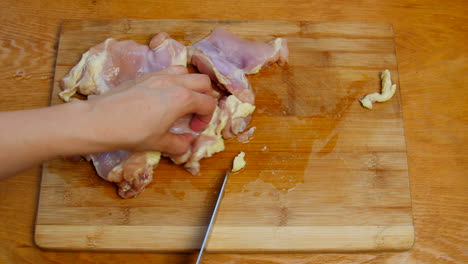 Cook-trims-fat-from-chicken-thighs