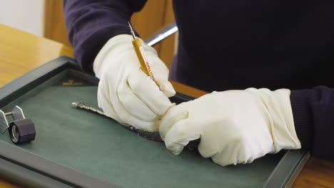 Coleccionista-De-Relojes-Profesional-Que-Trabaja-Con-Un-Reloj-Rolex-De-Lujo,-Usando-Guantes-Blancos-Para-Evitar-Manchas