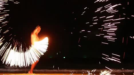 Ein-Thailändischer-Mann-Tanzt-Mit-Stahlwolle-Und-Ketten-In-Einer-Feuershow,-Bis-Er-Unzählige-Funken-Erzeugt,-Um-Touristen-Am-Strand-Der-Insel-Samet,-Thailand,-Zu-Unterhalten