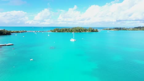Aerial-view-of-sailboat-in-turquoise-water-by-tropical-island