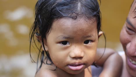 Porträt-Eines-Süßen-Kambodschanischen-Mädchens,-Das-Vom-Vater-Gehalten-Wird
