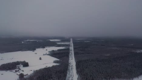 Aerial-view-of-power-line-road-in-snowy-cold-deep-forest