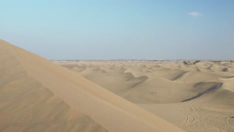 Statischer-Blick-Auf-Die-Dünen-Der-Emirate-In-Der-Nähe-Von-Dubai-Mit-Der-Stadt-Am-Horizont