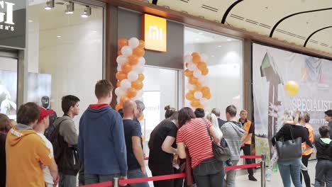 Crowd-of-people-waiting-for-Xiaomi-store-opening,-static-slowmo-shot