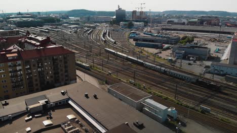 Vista-Aérea-Sobre-Los-Rieles-Que-Van-A-La-Estación-Central-De-Gotemburgo-Con-Trenes-Y-Tranvías