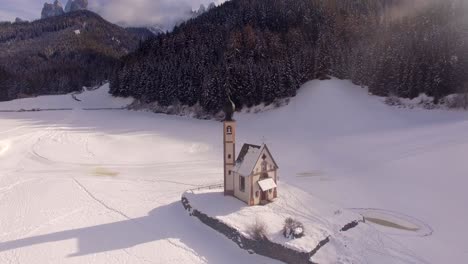 AERIAL:-Church-with-snow-in-Dolomites-in-Italy