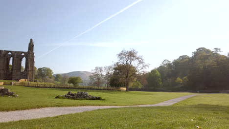 Pan-Reveal-of-Bolton-Abbey-Ruins-on-a-Beautiful-Sunny-Summer’s-Morning-in-Yorkshire,-England-with-Lens-Flare