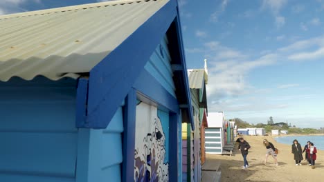 Tourists-walking-and-taking-photo-at-Brighton-Bathing-Boxes,-Melbourne,-Australia