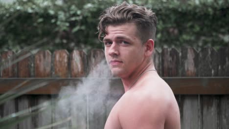Male-Model-Looking-Back-at-Camera-Blowing-Smoke-Slow-Motion