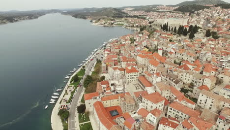 Flying-over-the-city-of-Sibenik,-panoramic-view-of-the-old-town-center-and-coast