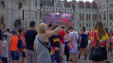 Gente-Colorida-Preparándose-Para-Marchar-En-El-Orgullo-De-Budapest,-Reuniéndose-Frente-Al-Parlamento