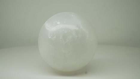 White-Crystal-Round-l-Magic-Ball-Rotating-Clockwise-With-Pure-White-Background--Close-Up-Shot