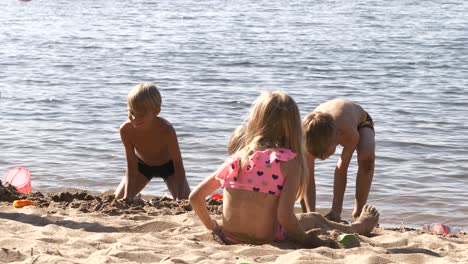 Zeitlupenaufnahme-Von-Sommerkindern,-Die-Am-Strand-Spielen-Und-Sandburgen-Bauen