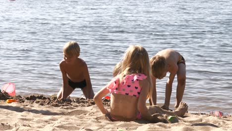 Toma-En-Cámara-Lenta-De-Niños-De-Verano-Jugando-Y-Construyendo-Castillos-De-Arena-En-La-Playa