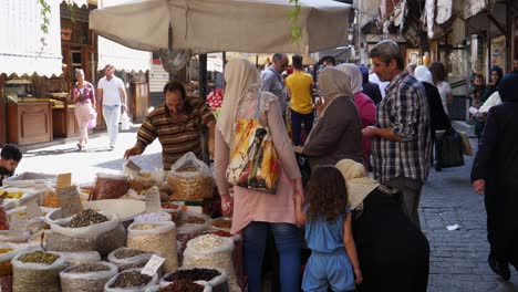Hombre-Que-Vende-Variedades-De-Nueces-Y-Está-Rodeado-De-Sus-Clientes-En-Un-Bazar-En-Damasco