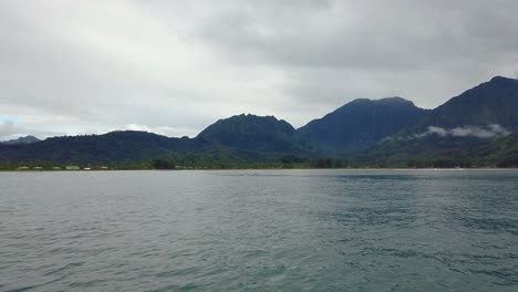 4K-Hawaii-Kauai-Bootfahren-Auf-Dem-Meer,-Das-Von-Rechts-Nach-Links-Schwebt,-Mit-Einer-Von-Links-Nach-Rechts-Verlaufenden-Hügel--Und-Berglandschaft-In-Wolken