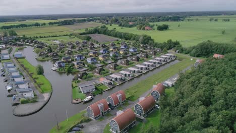 Wide-Aerial-of-Small-Dutch-Holiday-Park-during-Summer-with-Different-Kind-of-Houses-and-Countryside-in-background