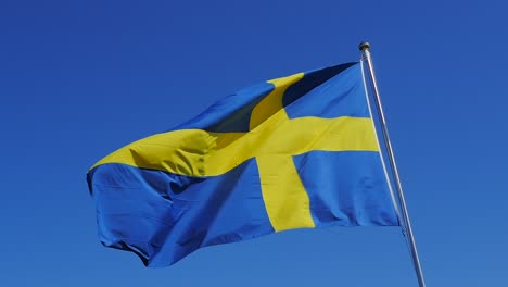 Nahaufnahme-Der-Schwedischen-Flagge-In-Zeitlupe-An-Einem-Klaren,-Sonnigen-Tag