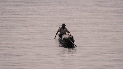 Pescador-Perfilando-Mientras-Lanza-Y-Saca-Su-Red-En-El-Río-Antes-Del-Anochecer,-En-Cámara-Lenta