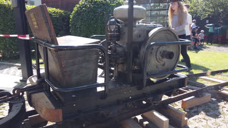 An-old-tractor-machine-engine-running-into-a-small-railway-or-the-mono-rail-with-people-in-the-background