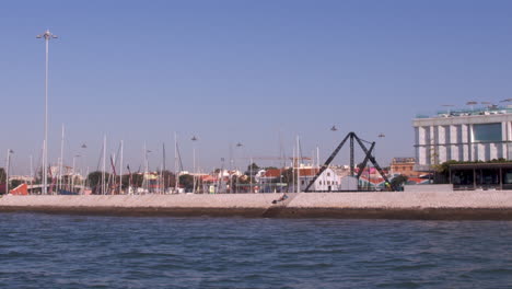 Belem-marina-shot-by-boat-on-the-river-tejo,-Lisbon,-Portugal