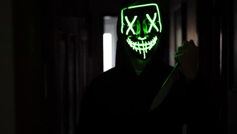 Ein-Furchteinflößender-Mörder-In-Einer-Generischen,-Anonymen-Halloween-Maske,-Der-Ein-Verängstigtes-Opfer-Mit-Einem-Messer-Jagt