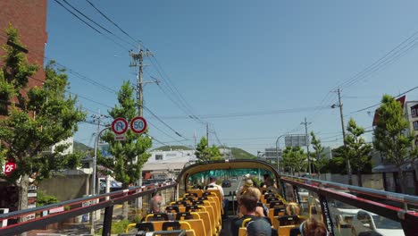 Touristic-hop-on-hop-off-bus-tour-with-open-double-decker-through-the-Japanese-city-of-Kyoto