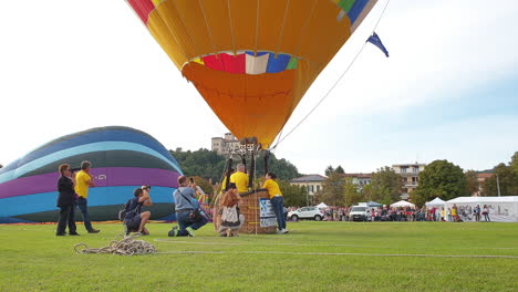 Preparando-Un-Globo-De-Aire-Caliente-Bajo-El-Cielo-Despejado-De-Italia,-Tiro-De-ángulo-Bajo