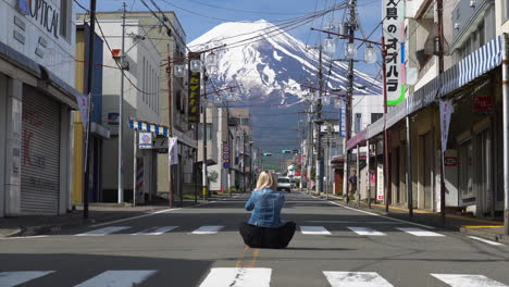 Eine-Frau-Sitzt-Auf-Den-Straßen-Von-Fujiyoshida-Und-Fotografiert-Den-Berg
