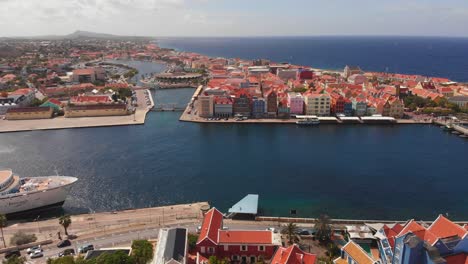 Epische,-Aufschlussreiche-Luftaufnahme-Von-Willemstad,-Curaçao,-Mit-Einem-Kreuzfahrtschiff,-Das-In-Der-Bucht-Von-Sint-Anna-Anlegt
