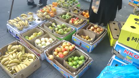 An-African-american-woman-street-vendor-bagging-fruit-for-a-customer-on-a-street-market-in-central-Cape-Town