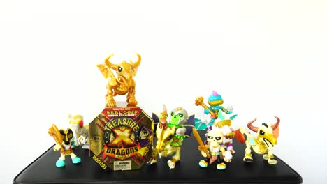 Die-Kamera-Zoomt-Langsam-Heraus,-Um-Die-Goldene-Spielzeugkiste-Von-Treasure-X-Dragons-Mit-Minifiguren-Zu-Zeigen,-Die-Sie-Umgeben