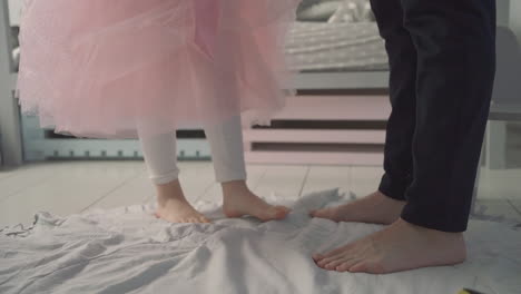 Little-daughter-dances-on-her-daddy's-feet-at-home.-Father's-day.