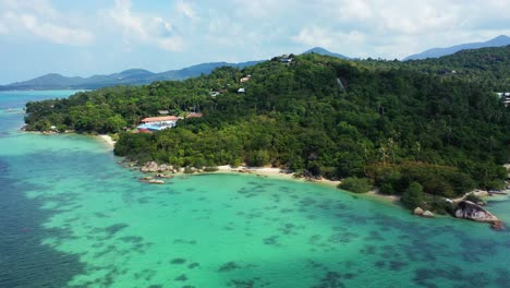 Paradise-holiday-resort-surrounded-by-tropical-forest,-small-unspoiled-exotic-beach-washed-by-turquoise-lagoon-in-Thailand