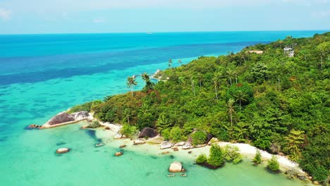 Paradise-tropical-island-with-palm-trees-forest-and-exotic-sandy-beach-hidden-through-beautiful-cliffs-washed-by-turquoise-sea,-Thailand