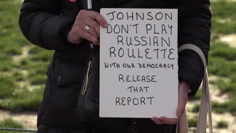 A-pro-European-protestor-holds-a-handmade-cardboard-white-placard-demanding-Prime-Minister-Boris-Johnson-release-the-report-into-Russian-interference-in-UK-politics
