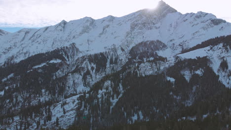 Aufsteigender-Vorwärtsflug-In-Richtung-Eines-Riesigen-Berges,-Schneebedeckte-Hügel,-Wald-Im-Winter-An-Einem-Sonnigen-Tag