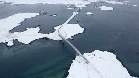Drone-footage-of-a-car-crossing-a-bridge-in-the-Lofoten-Islands,-Norway