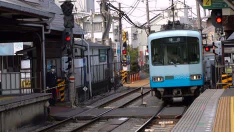 The-blue-Enoshima-Dentetsu-train-stopping-by-the-platform---wide-shot