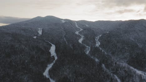 Old-ski-trails-winding-down-the-side-of-a-mountain-AERIAL-pull-back