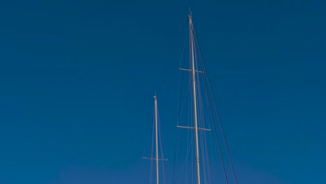 Embarcadero-with-superyachts-including-Dum-Luck-and-Desperado-parked-alongside-the-convention-center,-Tilt-down-from-the-sky-shot