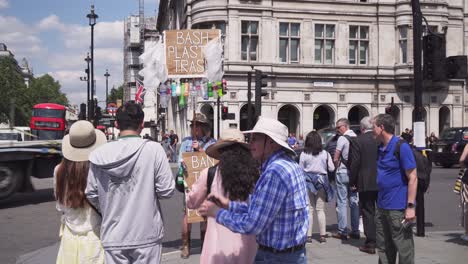 Activista-Que-Sostiene-La-Prohibición-De-Este-Cartel-De-Veneno-De-Plástico-En-London-Street,-Gente-Caminando