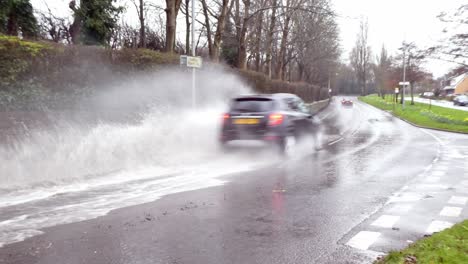 Autos-Spritzen-Durch-überschwemmte,-Stürmische,-Schwere-Sturzflutstraße