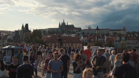 Tourist-walking-and-sightseeing-on-Charles-Bridge,-Castle-in-background-Prague,-Czech-Republic