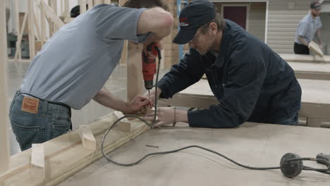 Instructor-De-Carpintería-Y-Estudiante-Trabajan-Juntos-En-Un-Proyecto-De-Construcción-En-Una-Escuela-De-Oficios