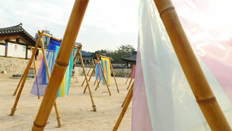 colorful-hanbok-fabric-hanging-on-traditional-korean-hanoaks-in-namsangol-hanoak-village